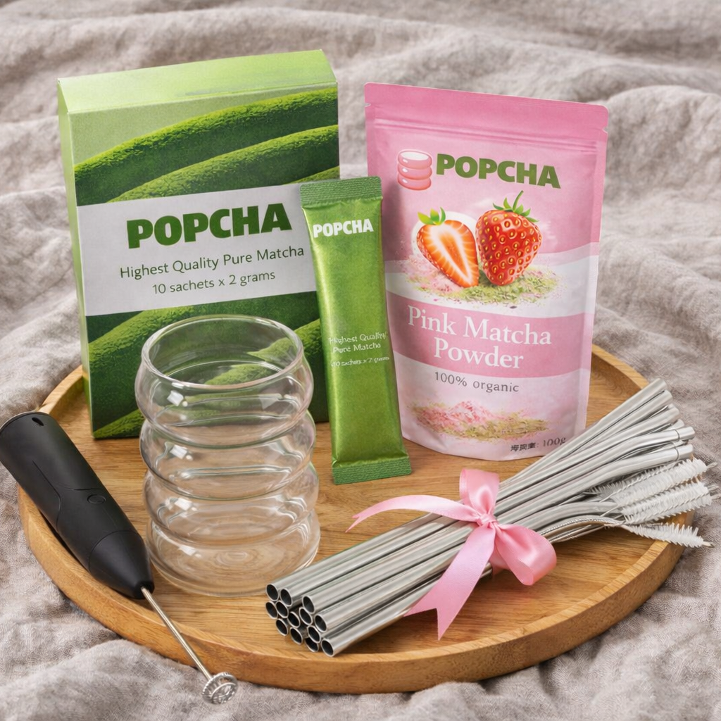 Popcha matcha set on wooden tray — matcha sachets, pink matcha powder, glass cup, frother and straws